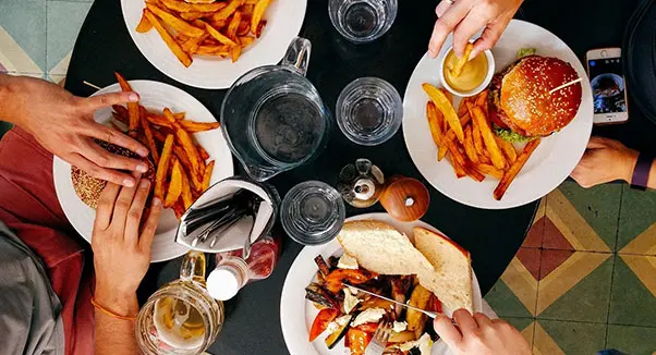 A table filled with plates of food and glasses.