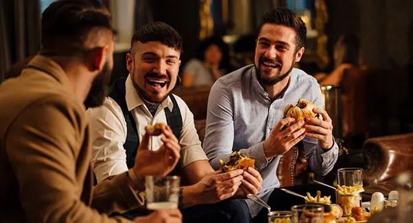 A group of men sitting around eating food.