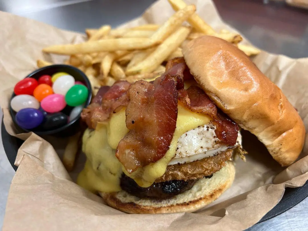 A bacon cheeseburger with fries and jelly beans.